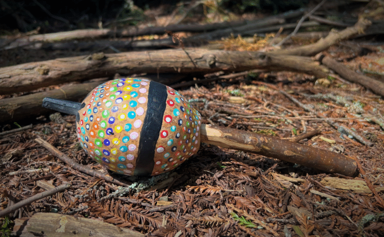 a colorful shamanic ratlte resting on the earth